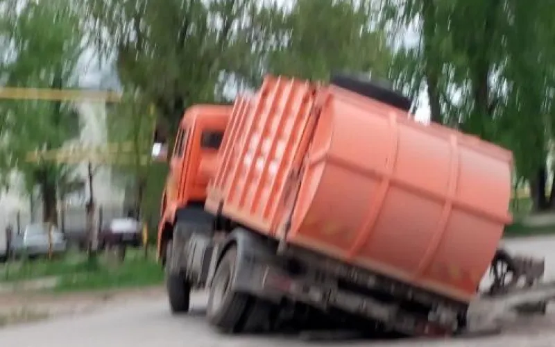 Мусоровоз застрял в яме в Барнауле 